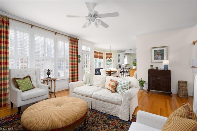 living area featuring ceiling fan, baseboards, and wood finished floors