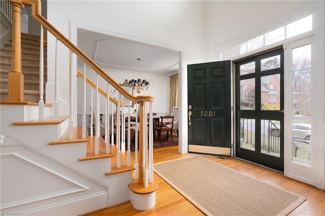 entrance foyer featuring a notable chandelier, wood finished floors, and stairs