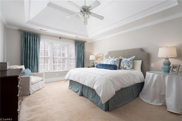 carpeted bedroom with ceiling fan, a tray ceiling, baseboards, and ornamental molding