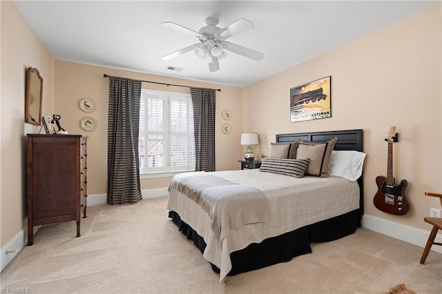 bedroom featuring visible vents, light colored carpet, baseboards, and ceiling fan