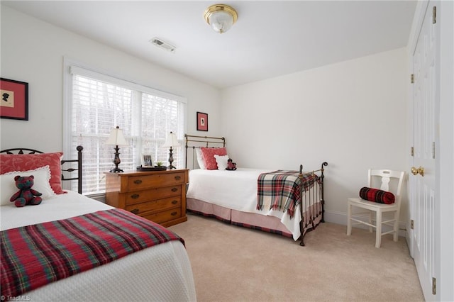 bedroom featuring baseboards, visible vents, a closet, and light carpet