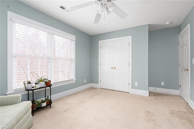 unfurnished room with visible vents, ceiling fan, baseboards, and carpet