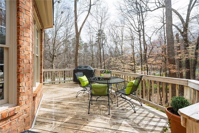 wooden terrace featuring outdoor dining area and area for grilling