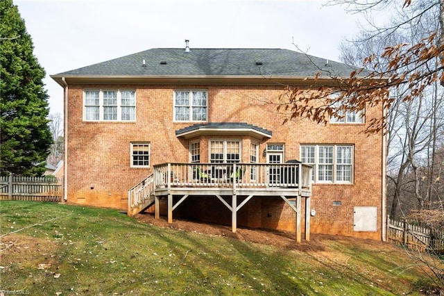 back of house with crawl space, brick siding, a yard, and fence