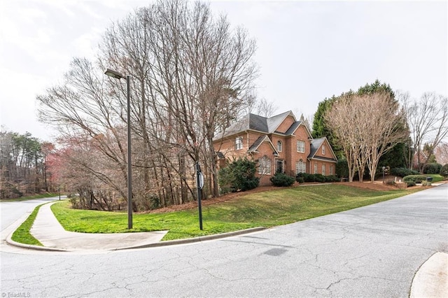 view of front of home featuring brick siding and a front yard