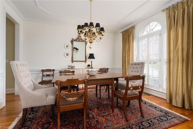 dining room featuring plenty of natural light, wood finished floors, and crown molding