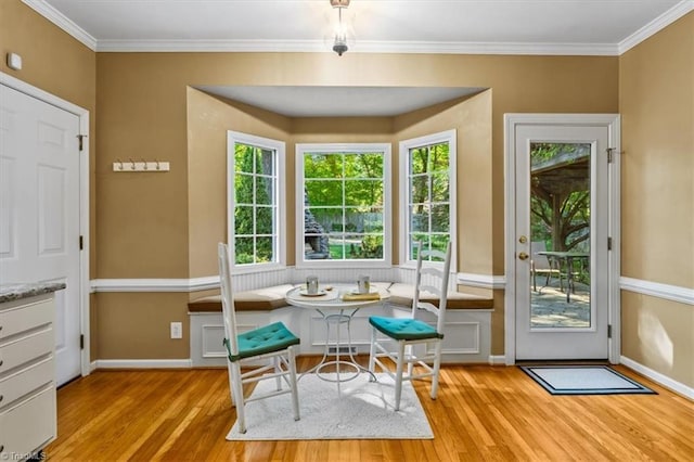 doorway with baseboards, ornamental molding, and wood finished floors