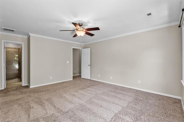 spare room featuring visible vents, crown molding, baseboards, a ceiling fan, and carpet