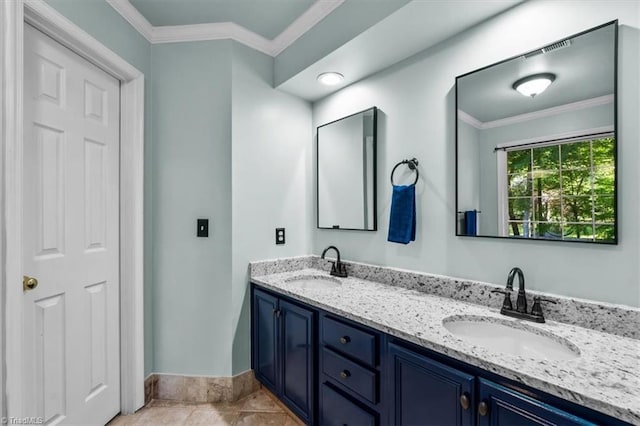 bathroom featuring crown molding, baseboards, and a sink