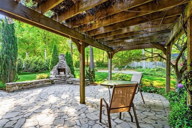 view of patio with fence, a pergola, and an outdoor stone fireplace