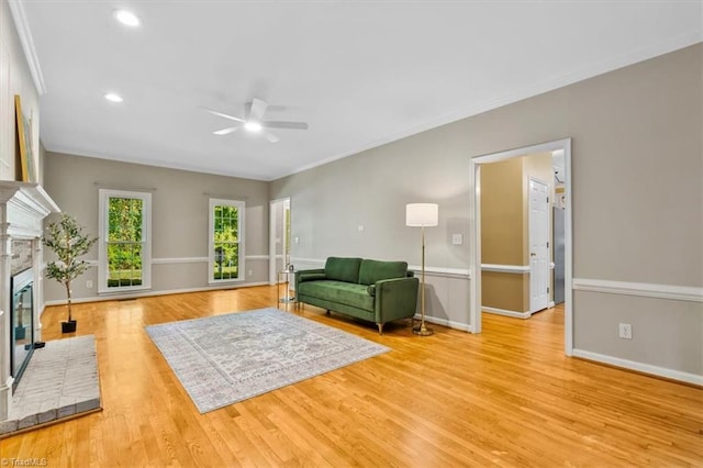 living room with ceiling fan, a brick fireplace, baseboards, light wood finished floors, and recessed lighting