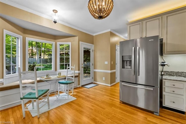 kitchen with ornamental molding, breakfast area, stainless steel fridge, a chandelier, and light wood-style flooring