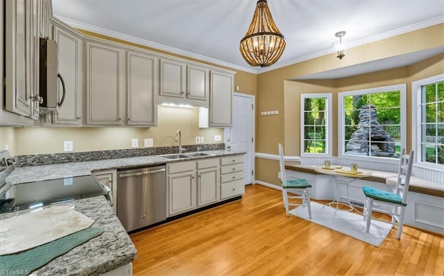 kitchen featuring a sink, appliances with stainless steel finishes, pendant lighting, and light wood-style flooring