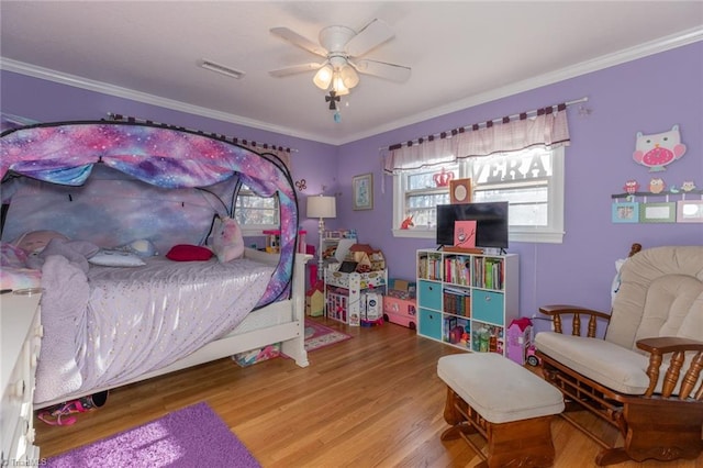 bedroom with ornamental molding, light wood-type flooring, and ceiling fan