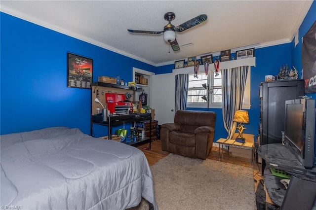 bedroom featuring hardwood / wood-style flooring, ceiling fan, and crown molding