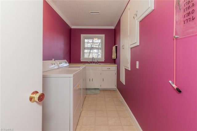 laundry room with cabinets, crown molding, sink, and washing machine and clothes dryer