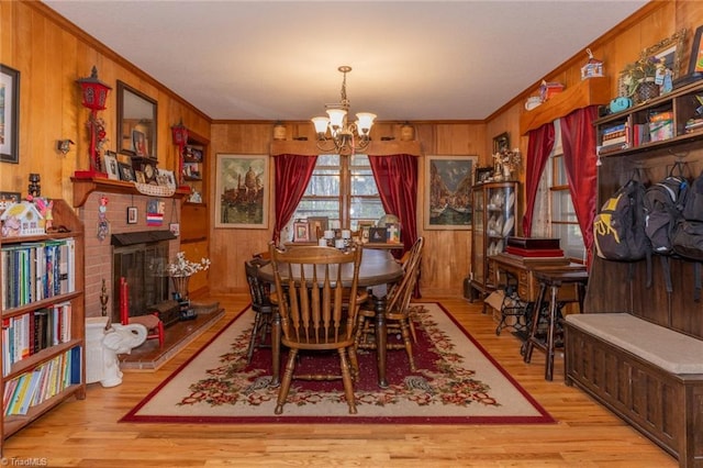 7715 W NC Highway 268, Wilkesboro, NC 28697 - dining room with a chandelier, crown molding, wood finished floors, wooden walls, and a fireplace