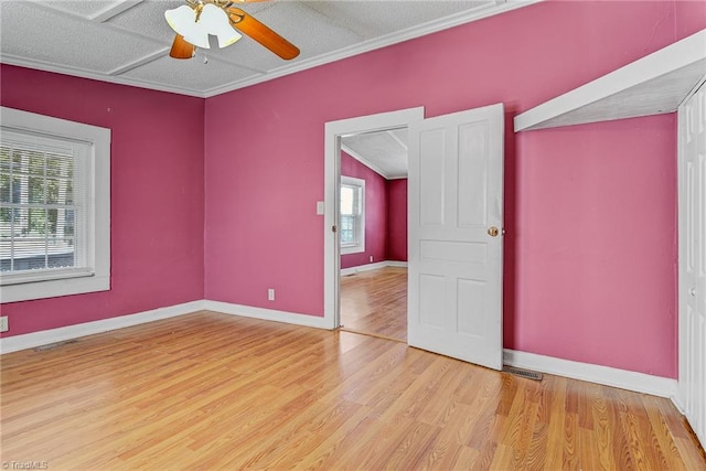 empty room featuring ceiling fan, ornamental molding, light hardwood / wood-style floors, and a healthy amount of sunlight