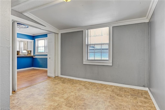 spare room with ornamental molding and light hardwood / wood-style flooring