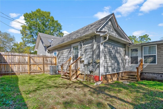 back of property with a lawn and central air condition unit