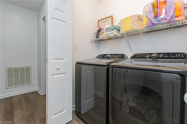 laundry room featuring visible vents, wood finished floors, separate washer and dryer, baseboards, and laundry area