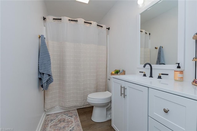 bathroom featuring curtained shower, toilet, vanity, and wood finished floors