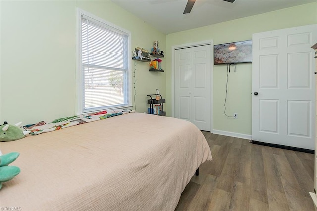 bedroom with dark wood finished floors, baseboards, a closet, and ceiling fan