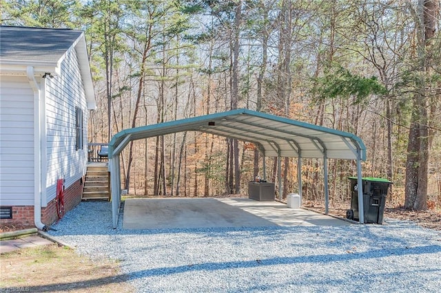 view of car parking with a carport, a view of trees, and driveway