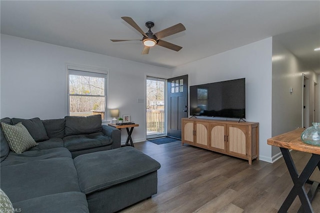 living room featuring wood finished floors, baseboards, and ceiling fan