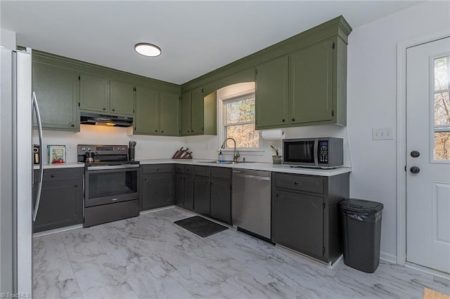 kitchen featuring ventilation hood, green cabinets, appliances with stainless steel finishes, marble finish floor, and a sink