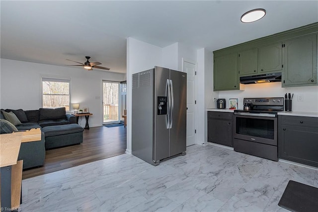 kitchen featuring ventilation hood, open floor plan, marble finish floor, stainless steel appliances, and green cabinetry