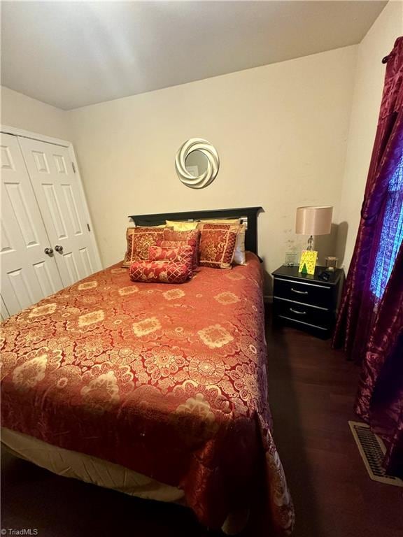 bedroom with dark hardwood / wood-style flooring and a closet