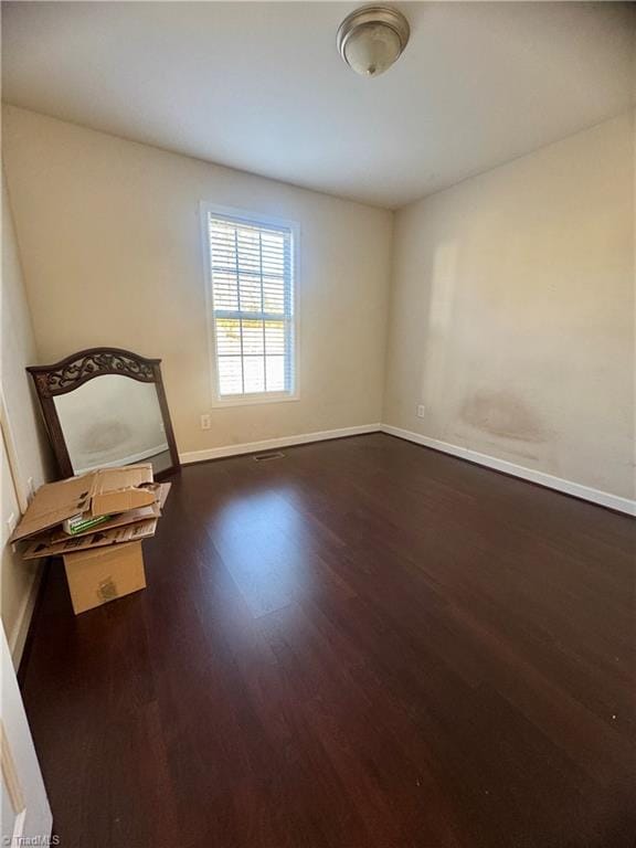 unfurnished room with dark wood-type flooring