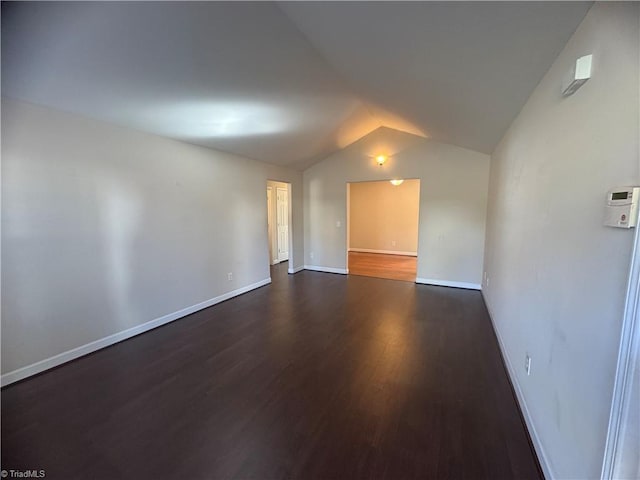 unfurnished room with dark hardwood / wood-style flooring and lofted ceiling