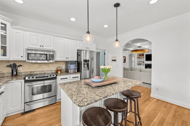 320 N Club Dr, Asheboro, NC 27205 - kitchen with appliances with stainless steel finishes, arched walkways, crown molding, a kitchen breakfast bar, and white cabinetry
