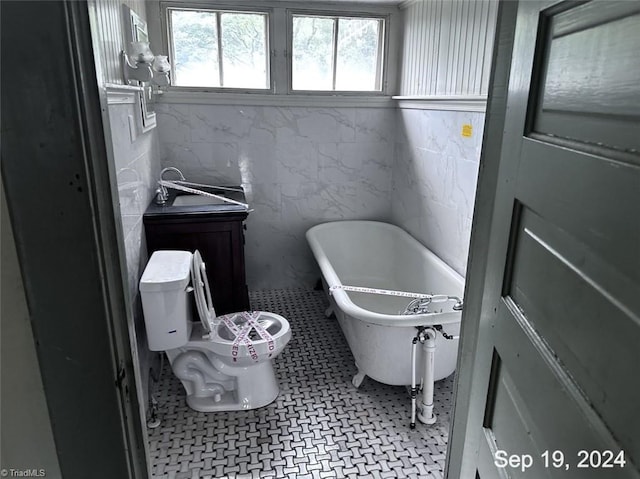 bathroom with vanity, toilet, a bath, and tile patterned floors