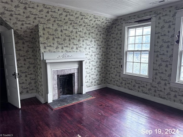 unfurnished living room featuring ornamental molding, lofted ceiling, a tiled fireplace, and dark wood-type flooring