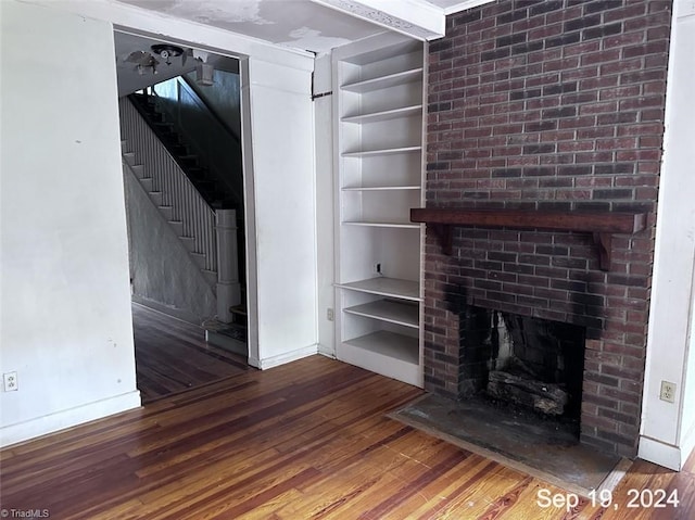 unfurnished living room with hardwood / wood-style flooring and a fireplace