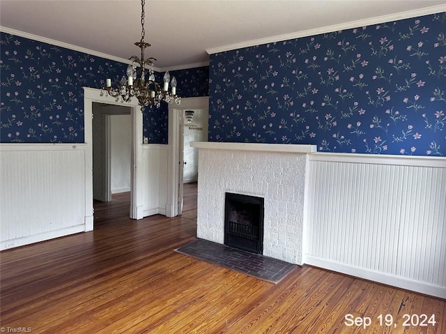 unfurnished living room with a notable chandelier, crown molding, and hardwood / wood-style floors