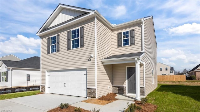 view of front of property with concrete driveway, stone siding, an attached garage, fence, and board and batten siding