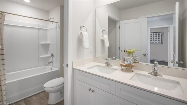 bathroom with shower / bath combo, wood finished floors, a sink, and double vanity