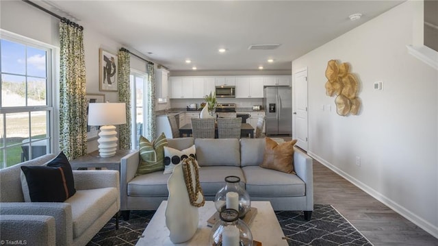 living room featuring recessed lighting, dark wood finished floors, and baseboards