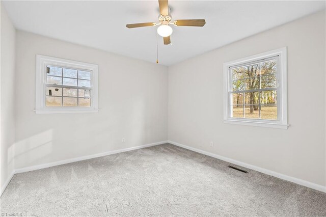 carpeted spare room featuring ceiling fan