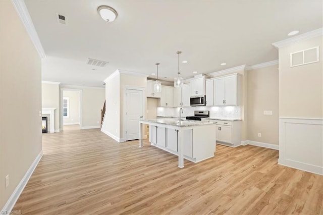 1087 Fairhaven Dr Lot 48, Mebane, NC 27302 - kitchen with appliances with stainless steel finishes, light wood-style floors, white cabinetry, crown molding, and decorative backsplash