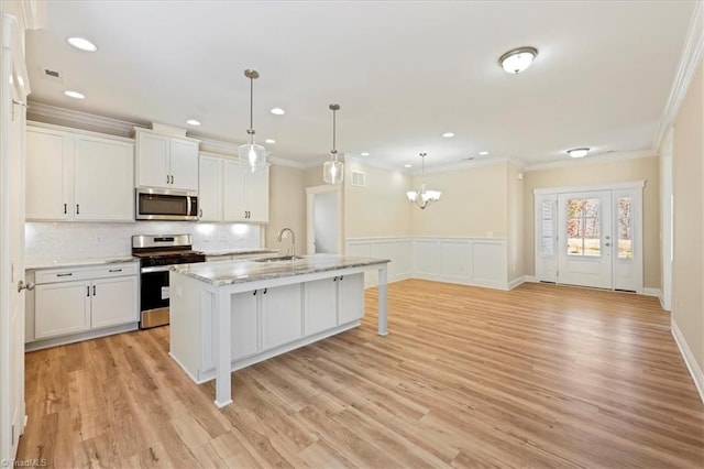 1087 Fairhaven Dr Lot 48, Mebane, NC 27302 - kitchen with stainless steel appliances, a sink, white cabinetry, light wood finished floors, and crown molding