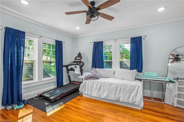 bedroom featuring multiple windows, wood finished floors, recessed lighting, ornamental molding, and a ceiling fan
