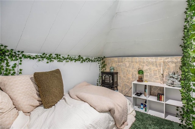 bedroom featuring a wood stove and vaulted ceiling