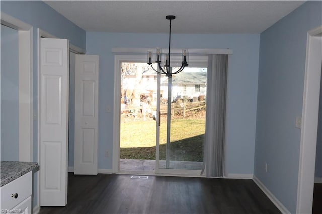 unfurnished dining area featuring dark hardwood / wood-style flooring and a chandelier