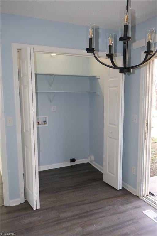 laundry area featuring dark hardwood / wood-style flooring, hookup for a washing machine, and a notable chandelier