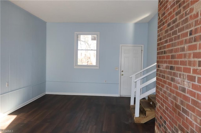 entryway with brick wall and dark hardwood / wood-style floors